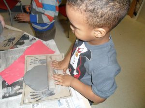 Rolling the clay into a pancake!